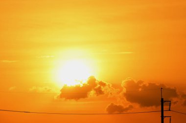 Günbatımı manzarası büyük şehirlerde güzel altın sarısı gökyüzü, gökyüzü ve parlak günlerdeki güzel bulutlarla elektrik iletim sistemi.