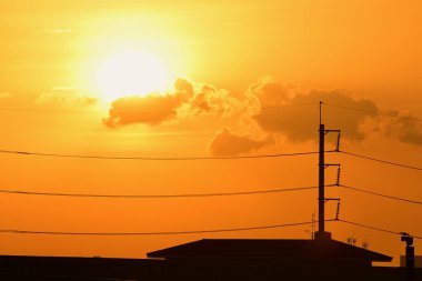Günbatımı manzarası büyük şehirlerde güzel altın sarısı gökyüzü, gökyüzü ve parlak günlerdeki güzel bulutlarla elektrik iletim sistemi.