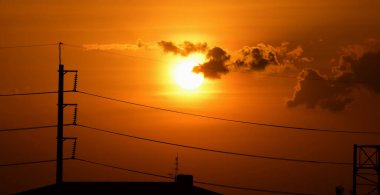 Günbatımı manzarası büyük şehirlerde güzel altın sarısı gökyüzü, gökyüzü ve parlak günlerdeki güzel bulutlarla elektrik iletim sistemi.