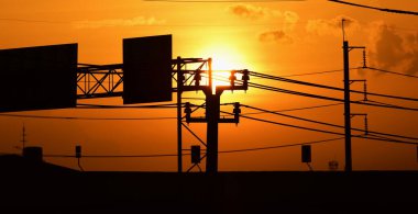 Günbatımı manzarası büyük şehirlerde güzel altın sarısı gökyüzü, gökyüzü ve parlak günlerdeki güzel bulutlarla elektrik iletim sistemi.