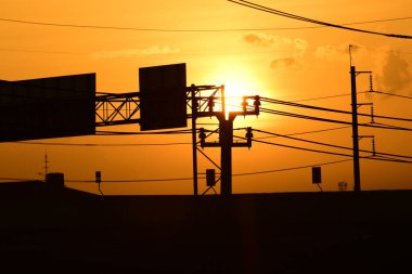 Günbatımı manzarası büyük şehirlerde güzel altın sarısı gökyüzü, gökyüzü ve parlak günlerdeki güzel bulutlarla elektrik iletim sistemi.