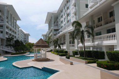 Güzel yüzme havuzu ve aydınlık bir günde gökyüzü manzaralı güzel bir bina..