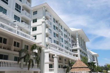 Güzel yüzme havuzu ve aydınlık bir günde gökyüzü manzaralı güzel bir bina..