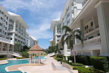 Güzel yüzme havuzu ve aydınlık bir günde gökyüzü manzaralı güzel bir bina..