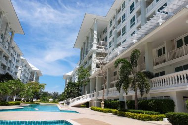 Güzel yüzme havuzu ve aydınlık bir günde gökyüzü manzaralı güzel bir bina..