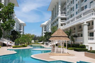 Güzel yüzme havuzu ve aydınlık bir günde gökyüzü manzaralı güzel bir bina..