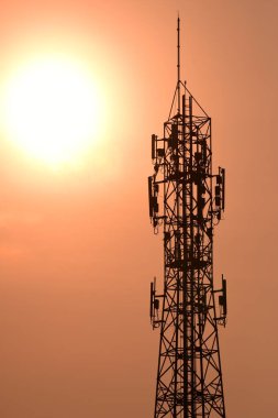 Günbatımında antenli telekomünikasyon kulesi