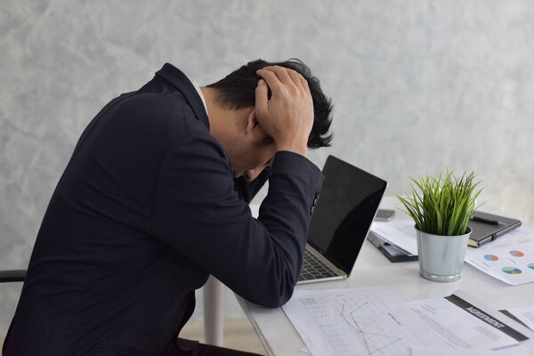 Asian businessman working on laptop computer in office 