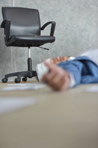 Мертвый бизнесмен на полу в офисе