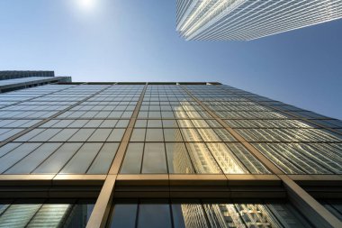 Parlak güneş ışığında yansımalı modern şehir gökdelenleri