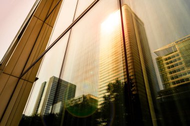 Parlak güneş ışığında yansımalı modern şehir gökdelenleri