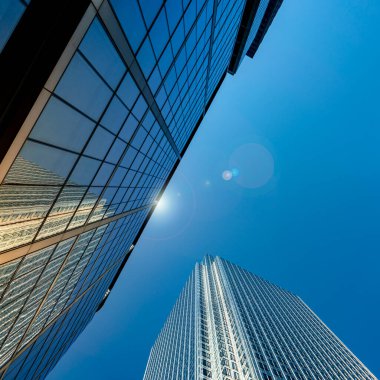 Parlak güneş ışığında yansımalı modern şehir gökdelenleri