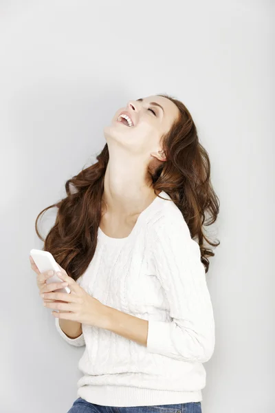 Vrouw lachen om haar telefoon — Stockfoto