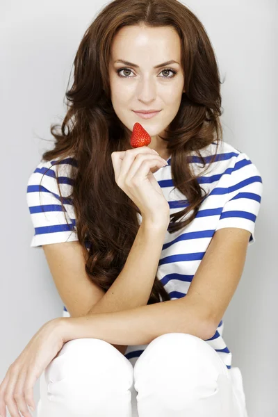 Young woman eating a strawberry — Stock Photo, Image