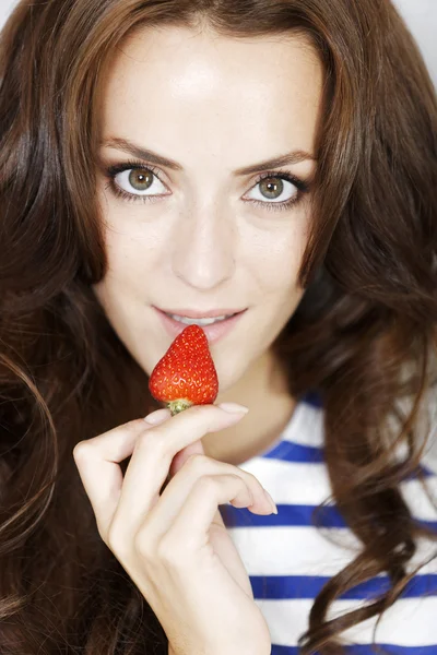 Młoda kobieta je truskawkę — Zdjęcie stockowe