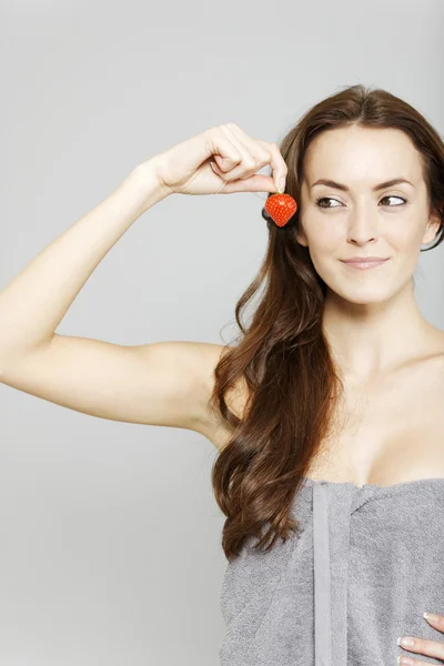 Woman holding up a strawberry — Stock Photo, Image