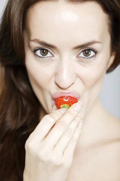Frau beißt in eine Erdbeere — Stockfoto
