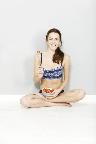 Kvinna som njuter av en skål med jordgubbar — Stockfoto