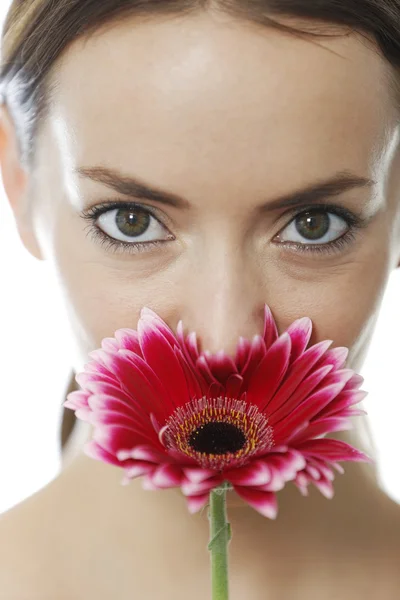 Женщина, нюхающая красный цветок — стоковое фото