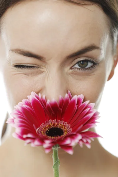 Mujer oliendo una flor roja — Foto de Stock