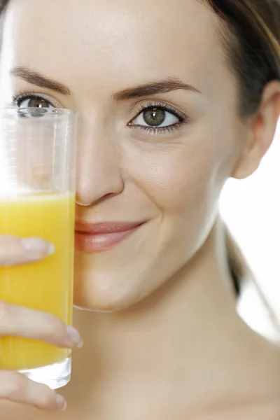 Mulher segurando um copo de suco de laranja — Fotografia de Stock