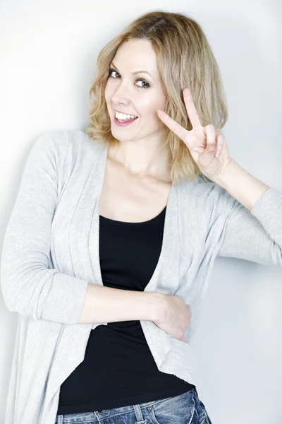 Happy woman displaying peace sign — Stock Photo, Image