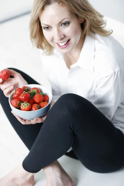 Vrouw eten van verse aardbeien — Stockfoto