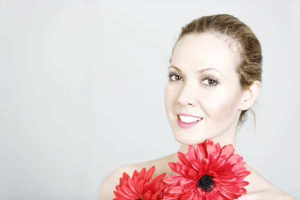 Woman holding red flowers — Stock Photo, Image