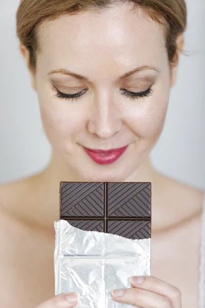 Woman eating large chocolate bar — Stock Photo, Image