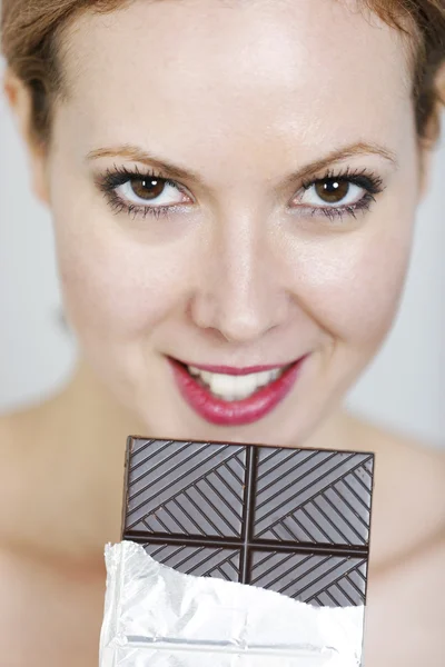 Woman eating large chocolate bar Royalty Free Stock Photos