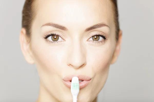 Mujer sonriendo sosteniendo el cepillo de dientes — Foto de Stock