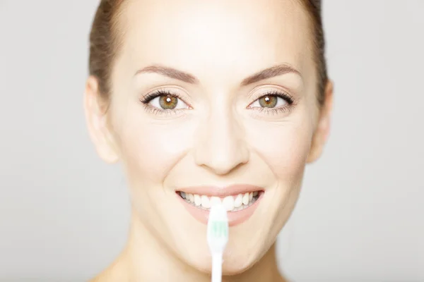 Woman smiling holding toothbrush — Stock Photo, Image