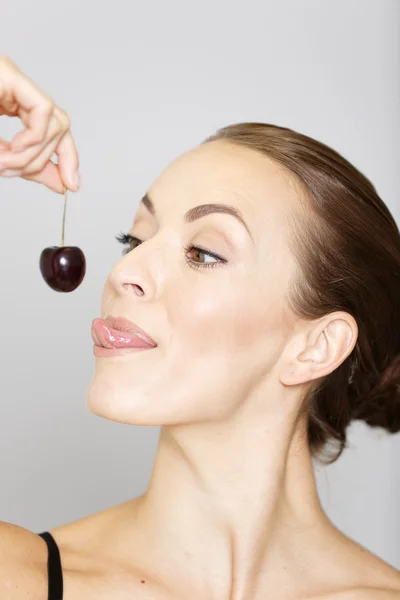 Woman holding up and eating fresh cherries — Stock Photo, Image