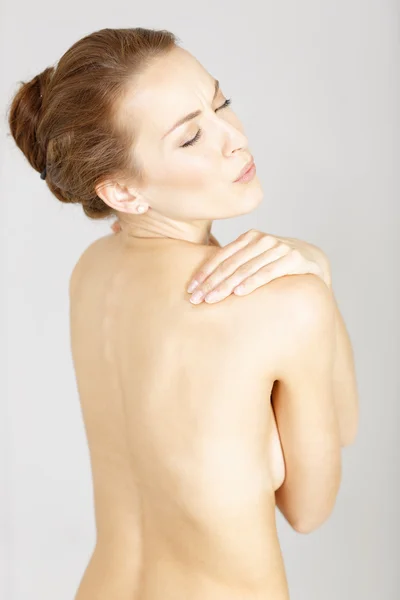 Жінка відвернулася масажуючи плече — стокове фото