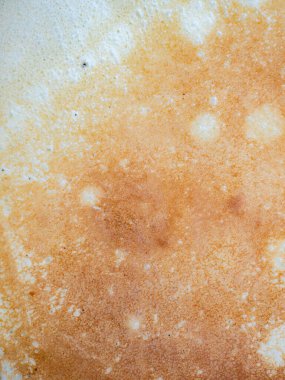 Golden brown surface of a freshly cooked pancake or crepe displaying its unique texture with small bubbles and crispy edges, indicating a delicious homemade breakfast or snack