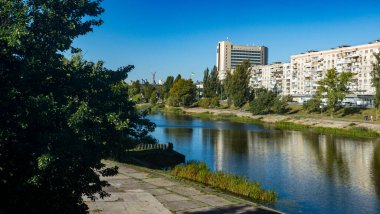 Rusanivka Canal flowing through Kyiv, representing the integration of residential architecture and public parkland within the urban environment, offering a harmonious blend of city and nature