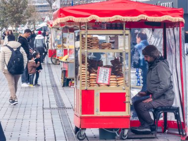 İstanbul, Türkiye - 8 Aralık 2025, İstanbul, Türkiye 'de yayalar üzerinde geleneksel Türk simit satan sokak satıcısı