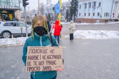 Kyiv, Ukrayna - 25 Ocak 2026: Maskeli Ukraynalı kadın Kyiv 'de düzenlenen mitingde savaş esirlerini savunan bir protesto tabelası taşıyor, devam eden çatışmaları vurguluyor
