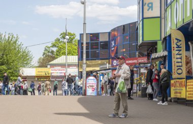 Kyiv, Ukrayna - 7 Mayıs 2022: Kyiv caddesi boyunca alışveriş yapan ve gezen insanlar, açık mavi gökyüzü ve gündüz hayatı altındaki dükkanlar ve mimariyle