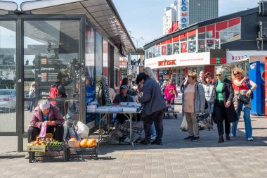 Kyiv, Ukrayna - 12 Mayıs 2022: Yayalar Kyiv 'deki bir otobüs durağını ve kentsel binaları geçerken kalabalık bir Livoberezhna sokak pazarında ürün satan satıcılar