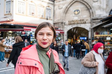 İstanbul 'da canlı caddeleri ve Kapalı Çarşı' nın tarihi girişini keşfeden genç bayan turist, yerel kültür ve alışveriş bölgeleriyle çevrili olarak solo macera yaşıyor.