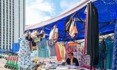 Kyiv, Ukrayna - 6 Mayıs 2023: Kyiv sokak satıcısı güneşli bir günde kalabalık bir açık hava pazarında mavi bir tuvalette iç çamaşırı ve giysi satıyor