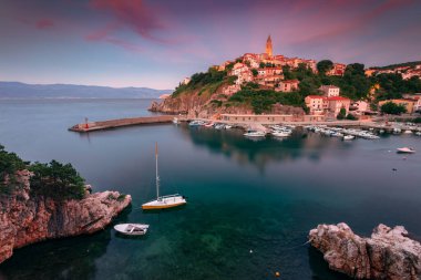 Vrbnik, Hırvatistan. Hırvatistan 'ın Vrbnik kentinde yaz günbatımında Krk Adası' nda bulunan pitoresk köyünün havadan çekilmiş görüntüsü.