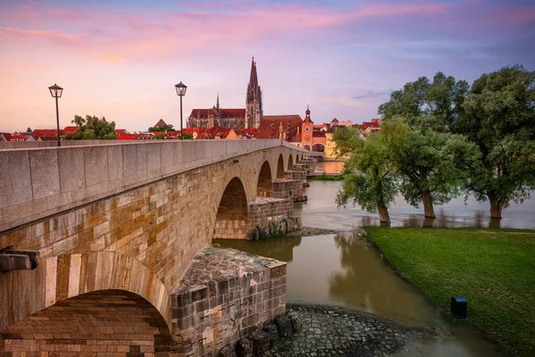 Regensburg, Almanya. Almanya 'nın Regensburg şehrinin Tuna Nehri üzerindeki Eski Taş Köprüsü ve St. Peter Katedrali' nin yaz gündoğumu görüntüleri.