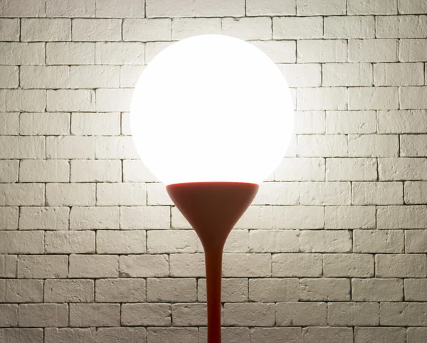 Лампа з формою кола на фоні білих цеглин — стокове фото