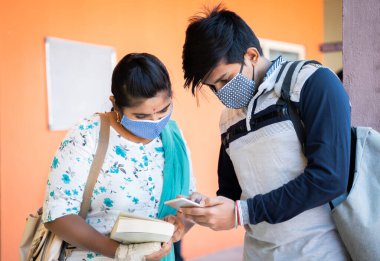 Tıp maskeli üniversite öğrencileri üniversite koridorunda cep telefonuyla meşguller - cep telefonu, teknoloji, internet ve üniversite kavramları covid-19 koronavirüs salgınından sonra yeniden açıldı