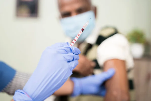 Focalizarea selectivă a mâinilor medicului care dețin vaccinul seringii pentru umărul pacientului la spital - conceptul de vaccinare covid-19 cu coronavirus . — Fotografie, imagine de stoc