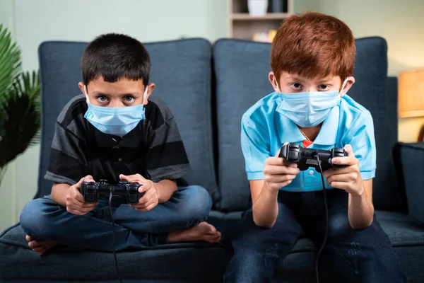 Δύο Παιδιά Ιατρική Μάσκα Προσώπου Σοβαρά Απασχολημένος Παίζοντας Βιντεοπαιχνίδι Χρησιμοποιώντας — Φωτογραφία Αρχείου