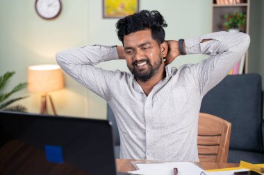 Yorgun genç adam işini bitirdikten sonra, barış, rahatlama ya da işi bitirmenin memnuniyeti kavramının arkasında el ele tutuşarak kendini rahatlamış hissediyor..