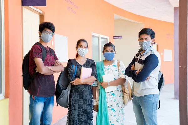 青いマスクを持つ少女に焦点を当て コロナウイルスやCovid 19パンデミックの際に着用された医療面マスクを持つ廊下で腕を組んで立つ大学生のグループ — ストック写真